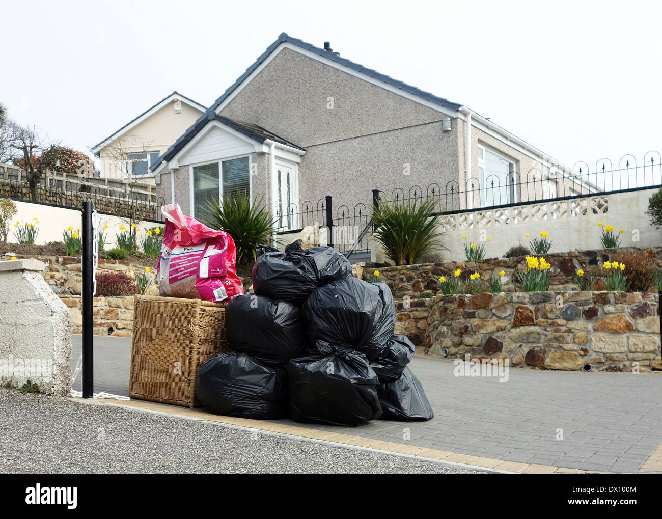 black bags of household waste left outside for collection by the local council refuse department Stock Photo