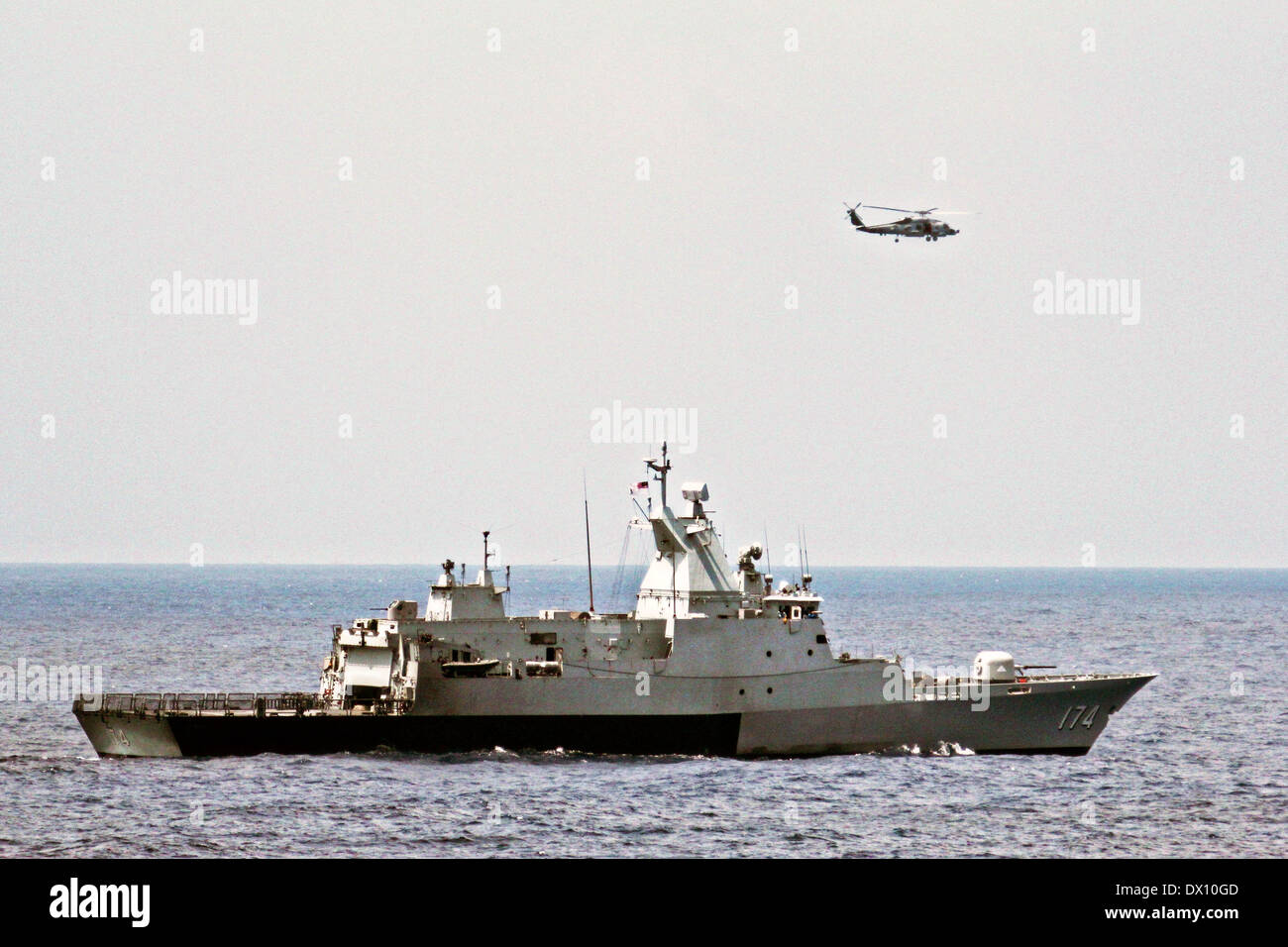 The Royal Malaysian Navy corvette KD Terengganu and a U.S. Navy MH60R