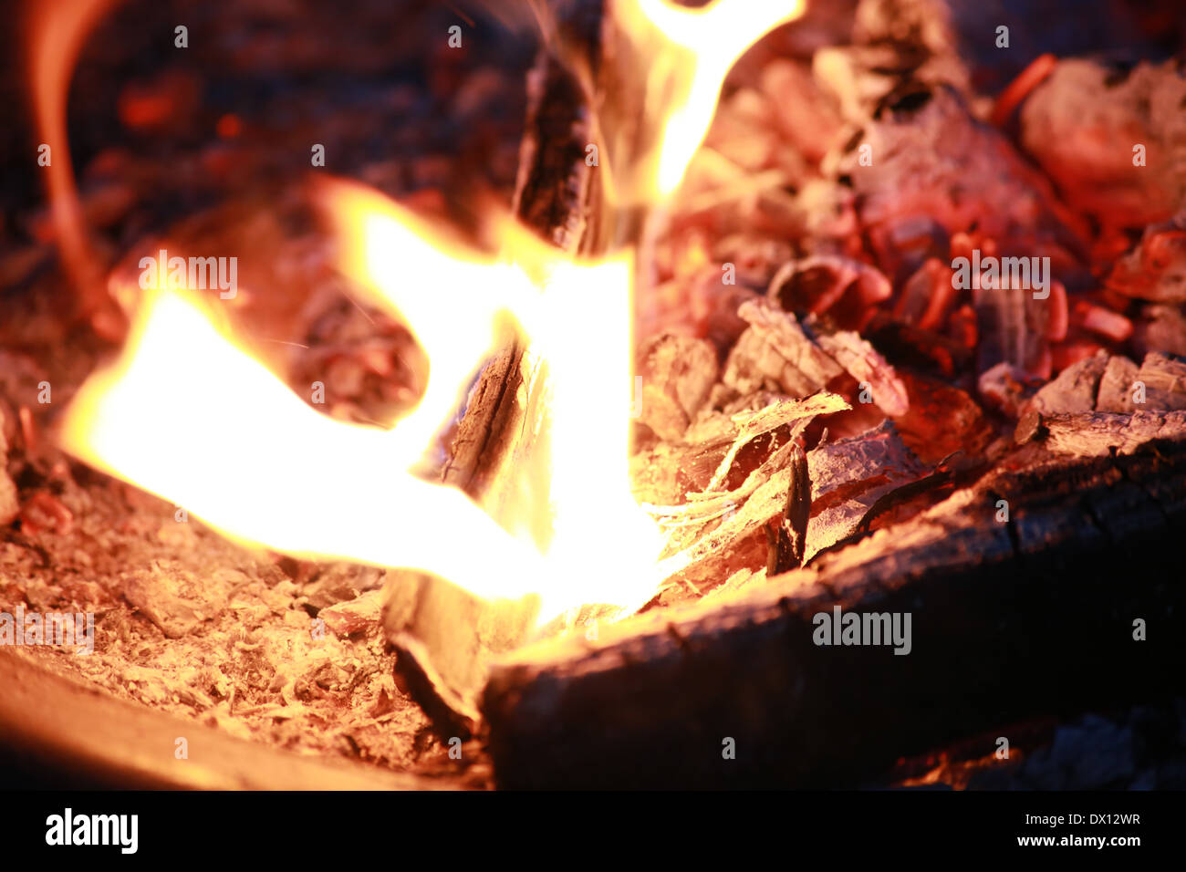 Fire burning in a firepit together with some embers and ashes Stock Photo