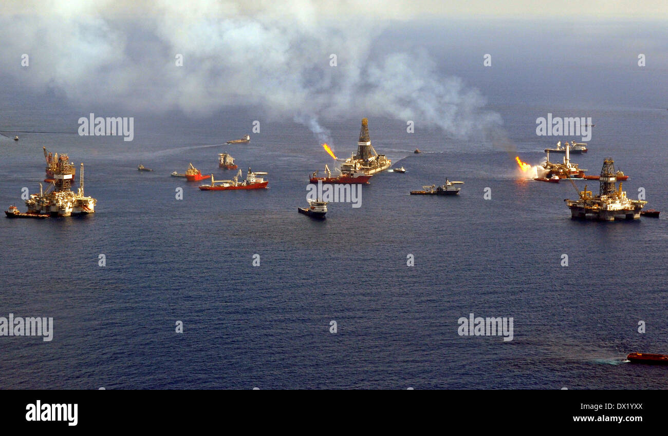 Oil skimming vessels operate around the the site of the Deepwater Horizon disaster as drill ship Discoverer Enterprise burns off gas from the wellhead June 26, 2010 in the Gulf of Mexico. Stock Photo