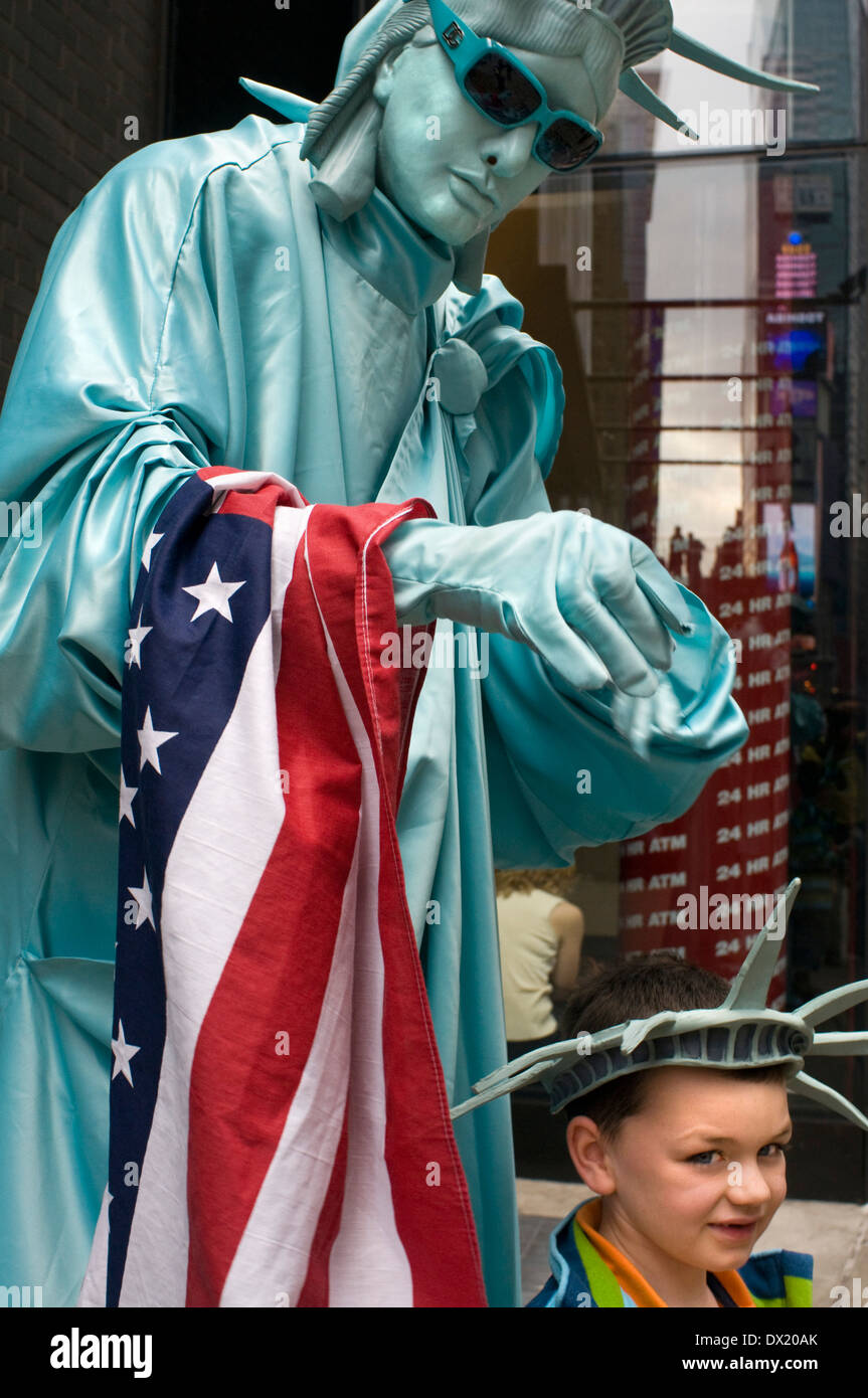 A human statue dressed in Statue of Liberty is pictured with a child near Times Square. If we want good photos of Times Square, Stock Photo