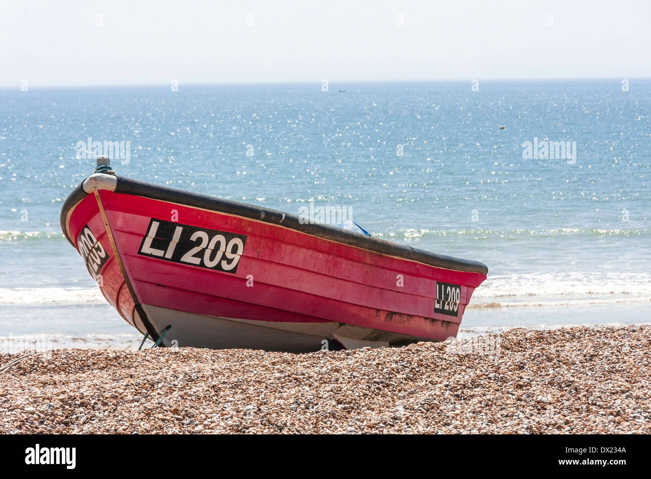 Boat on pebble beach Stock Photo - Alamy