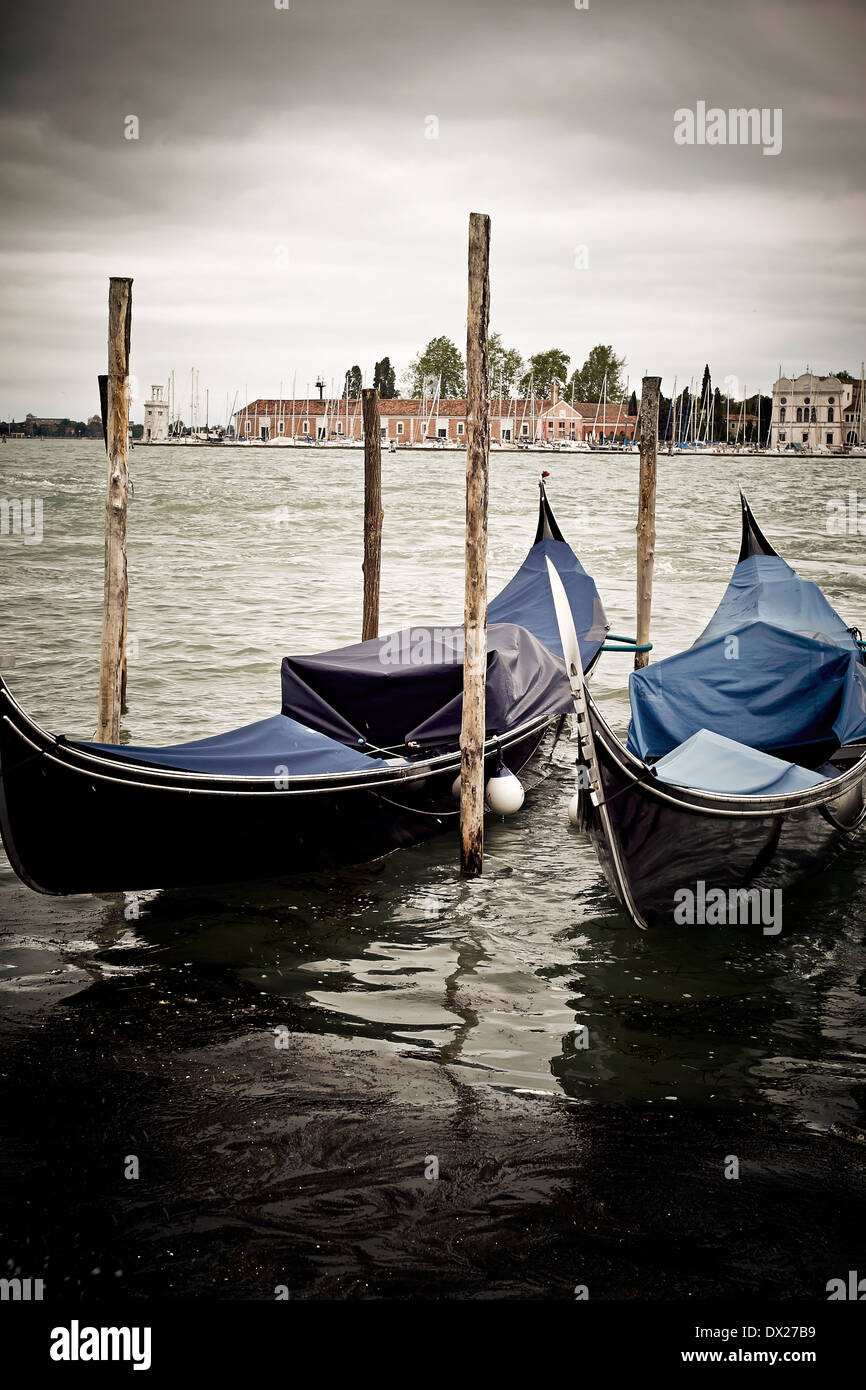 Gondolas moored in the Venetian Lagoon on a gray day. Stock Photo
