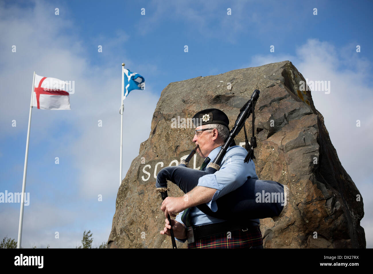 A man playing his bagpipes entertaining visitors to the border crossing