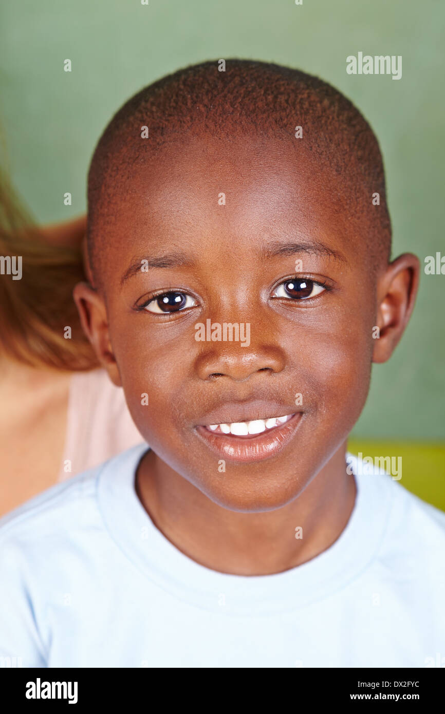 Portrait of a smiling african boy in front of a chalkboard Stock Photo