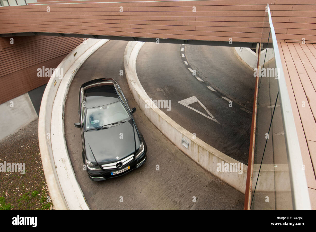 car driving down a ramp into an underground car park Stock Photo