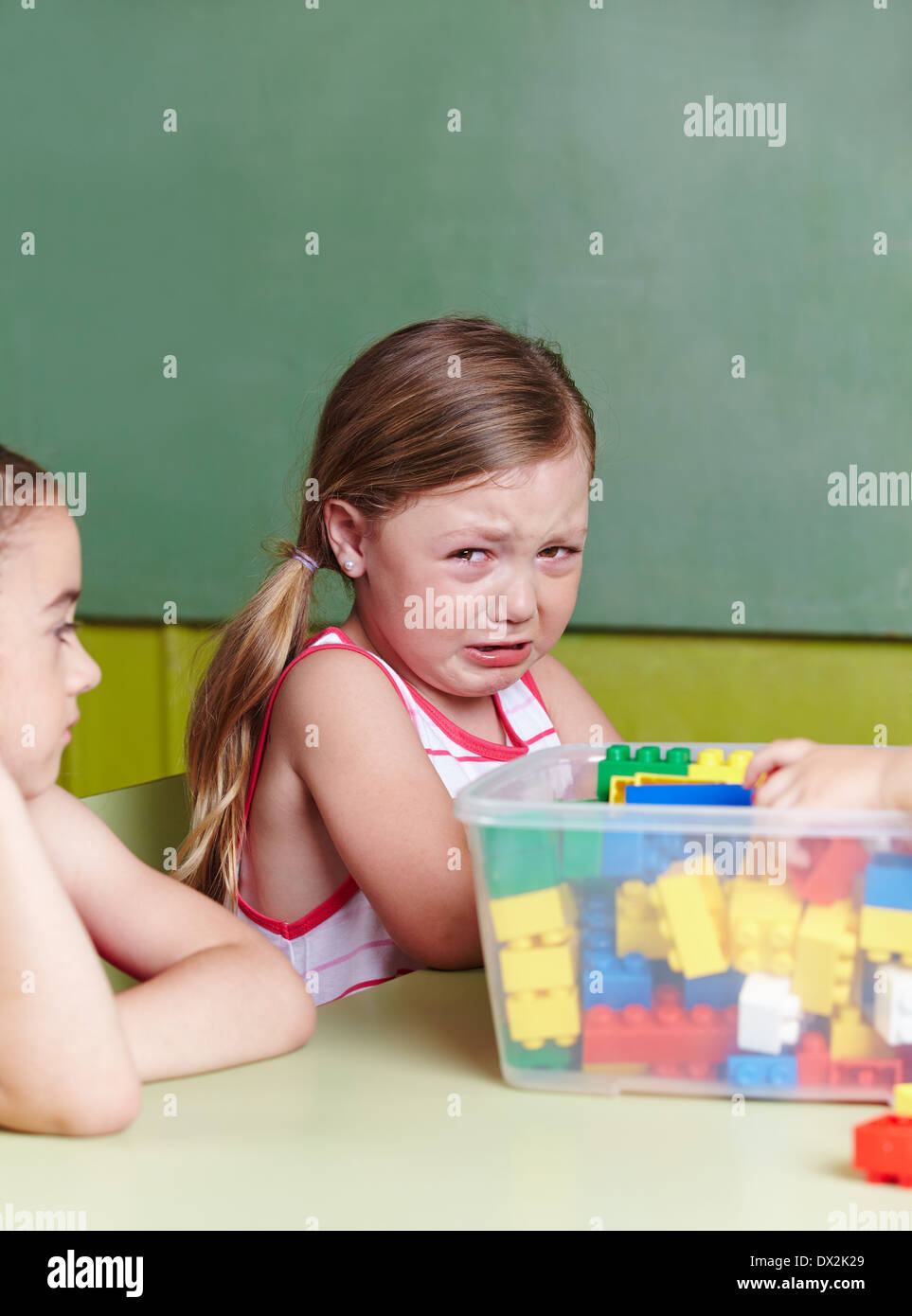 Sad girl crying in a kindergarten group Stock Photo