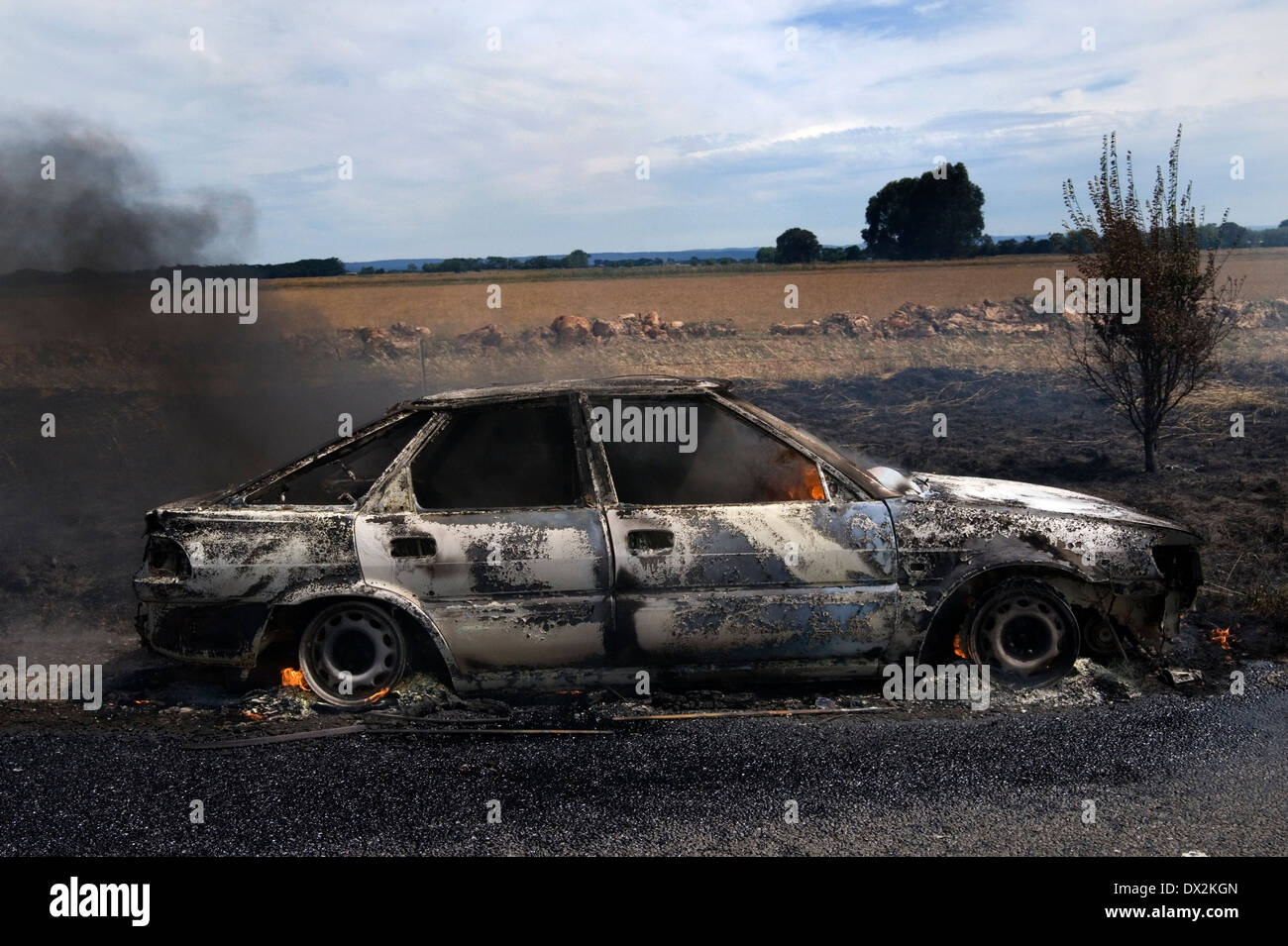 burnt out car smoking Stock Photo