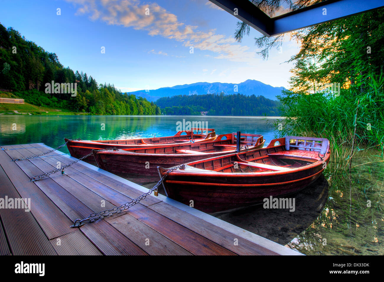 Boats on alpine lake in early morning Stock Photo