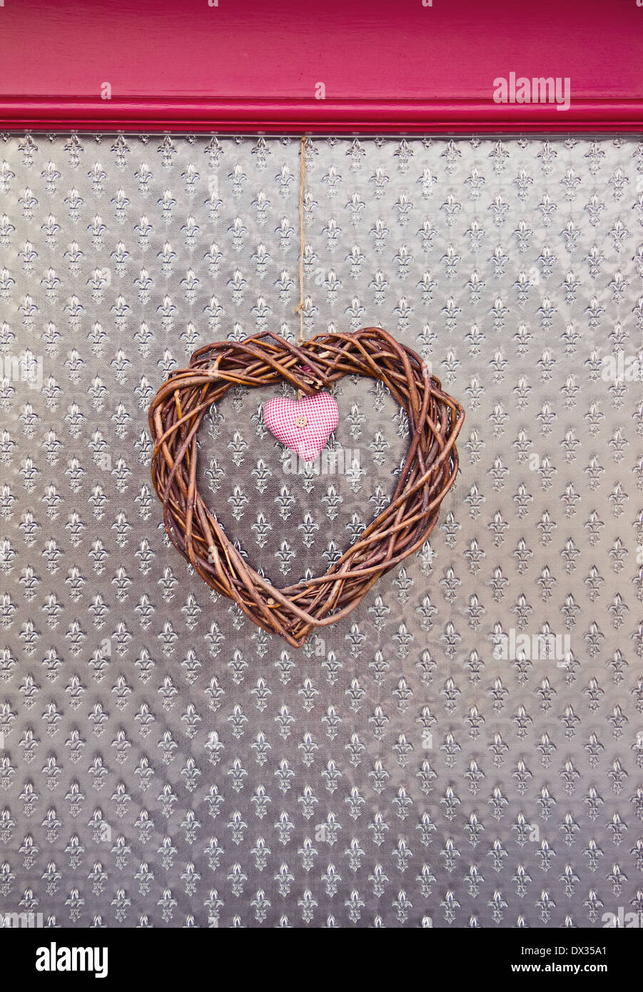 handmade faber and wicker decorative hearts over figured glass background Stock Photo