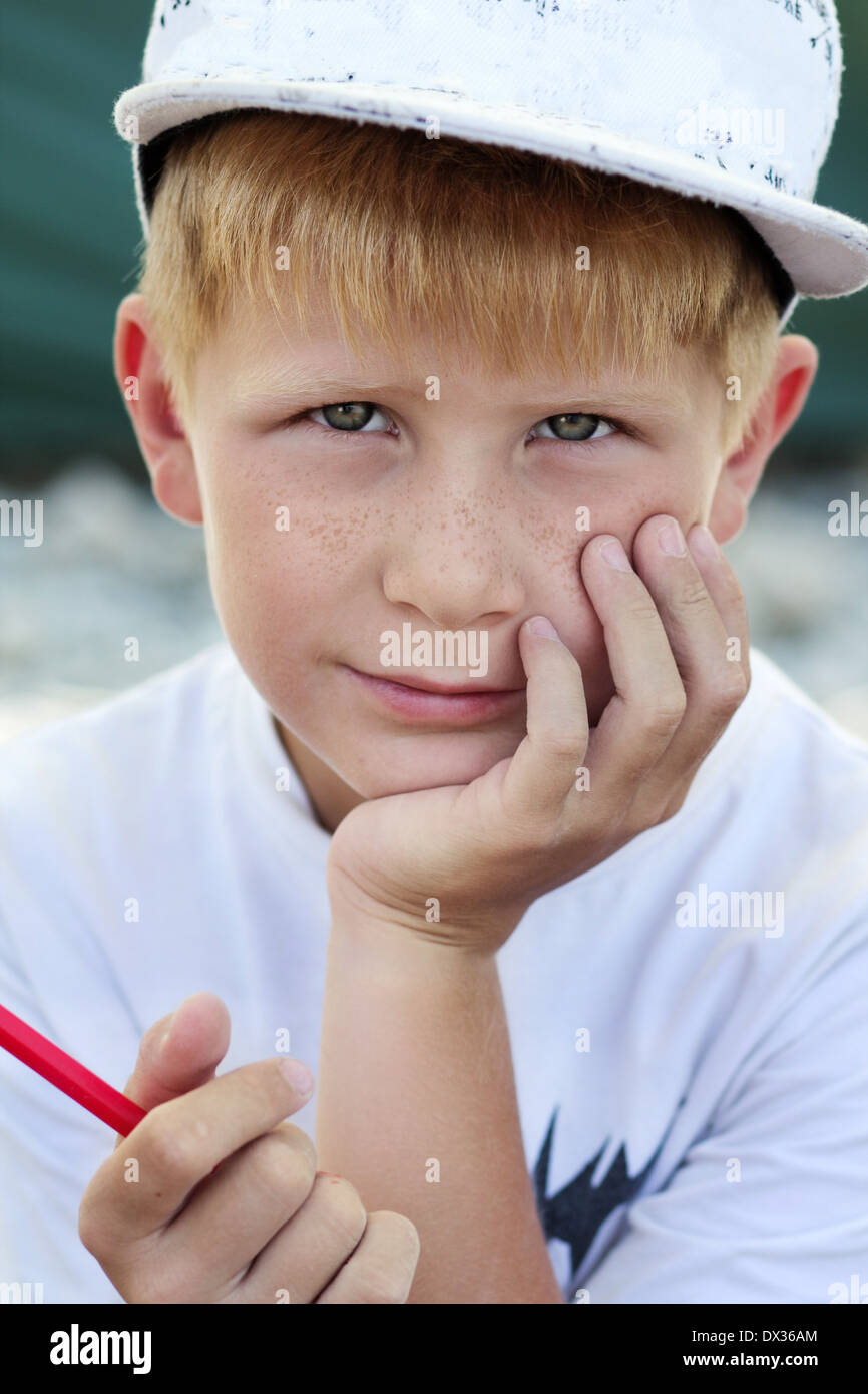 Closeup portrait of little boy in white t-shirt with red felt pen in his hand Stock Photo