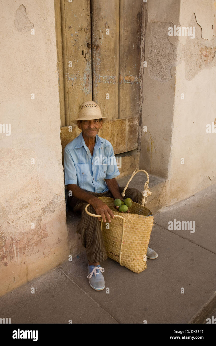 An old man sells mangoes in a Havana doorway Stock Photo