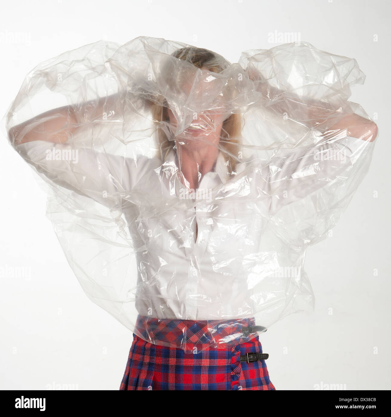 Woman putting on a plastic see through poncho mac Stock Photo