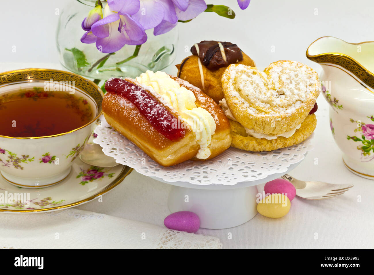 Traditional afternoon tea with cream cakes and vintage tea set. Stock Photo