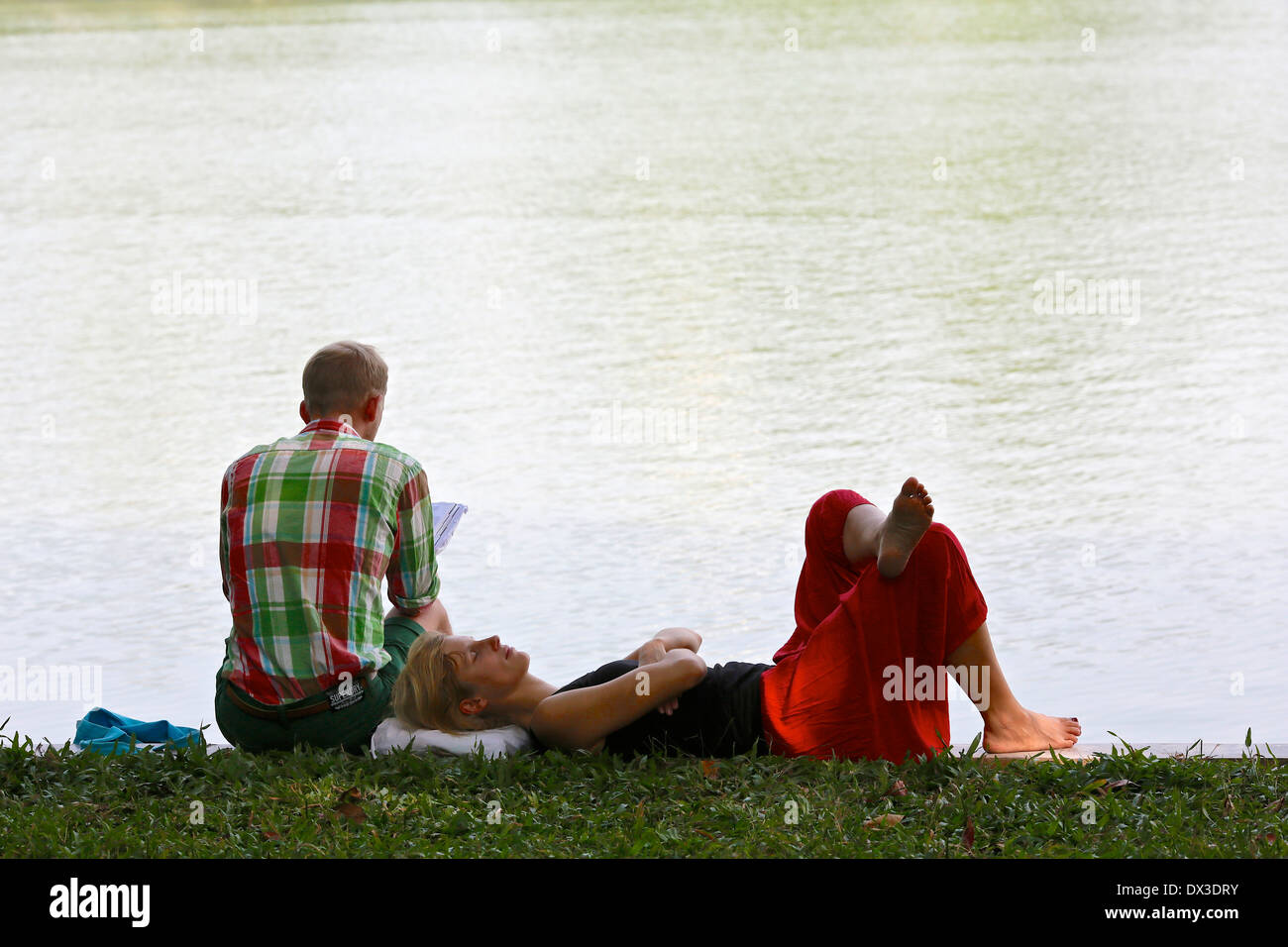 A young couple relax by the age of Hoan Kiem Lake. Hanoi, Vietnam, South East Asia Stock Photo