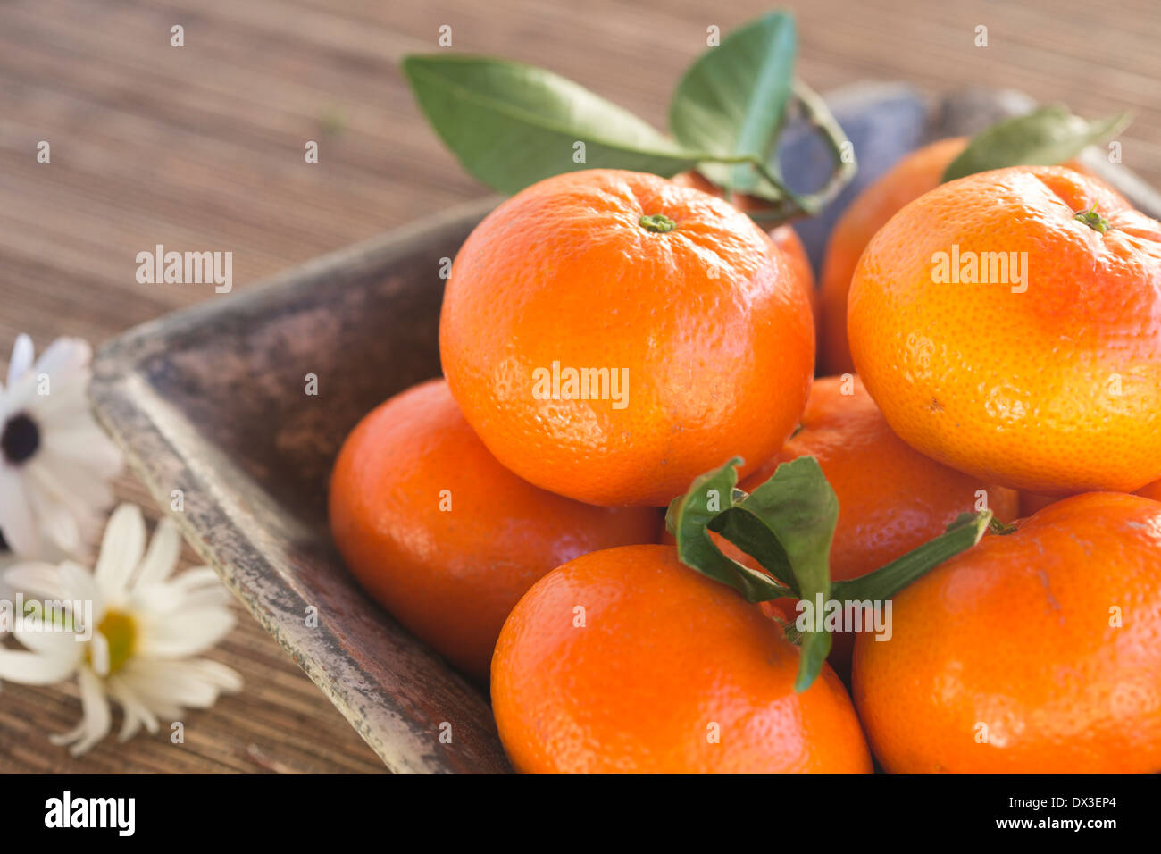 mandarins in a rustic blue bowl on a woven mat, Stock Photo