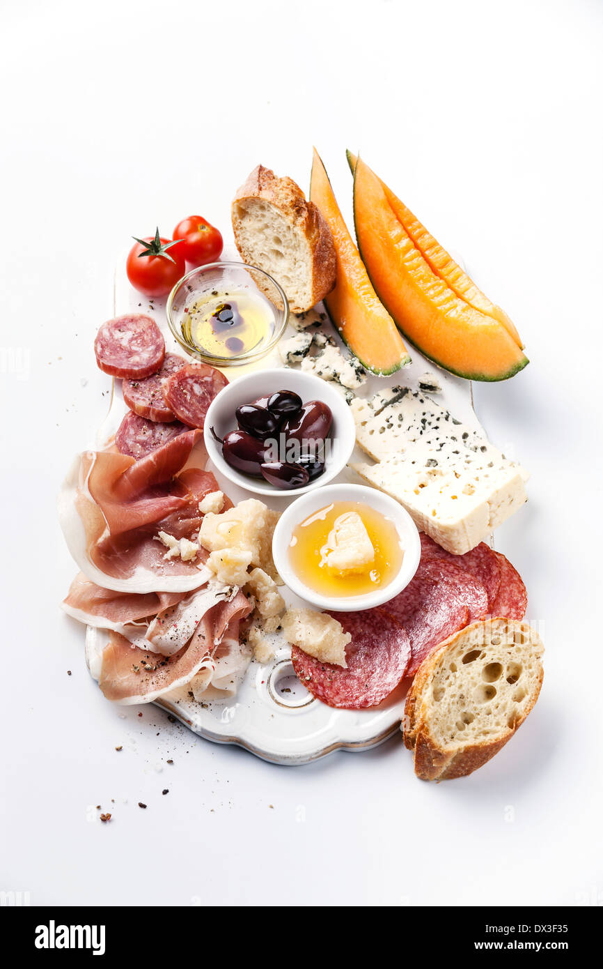 Antipasti ham, cheese, melon, olives, olive oil, bread Stock Photo