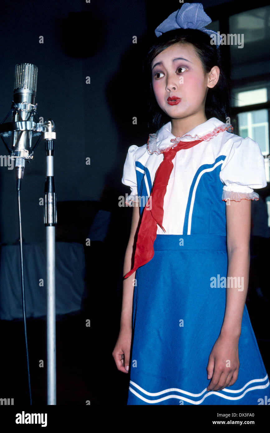 A pretty young Chinese girl with face makeup entertains foreign cruise ship passengers with songs at a banquet in Yantai, a large port city in China. Stock Photo