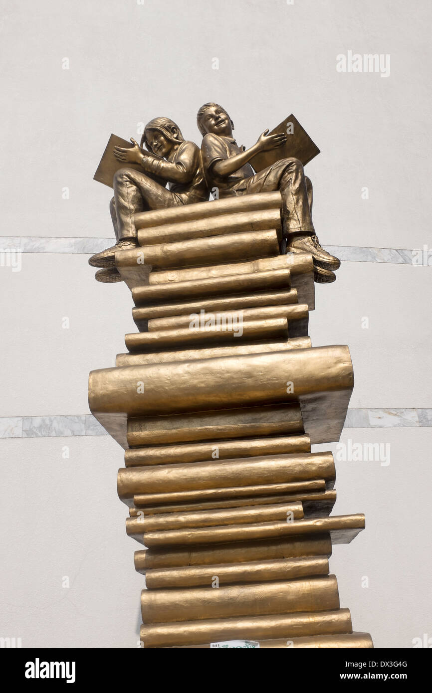 Modern art Sculpture of Boy and Girl reading on top of a stack of books outside the Bangkok Art and Culture Centre (BACC) Stock Photo