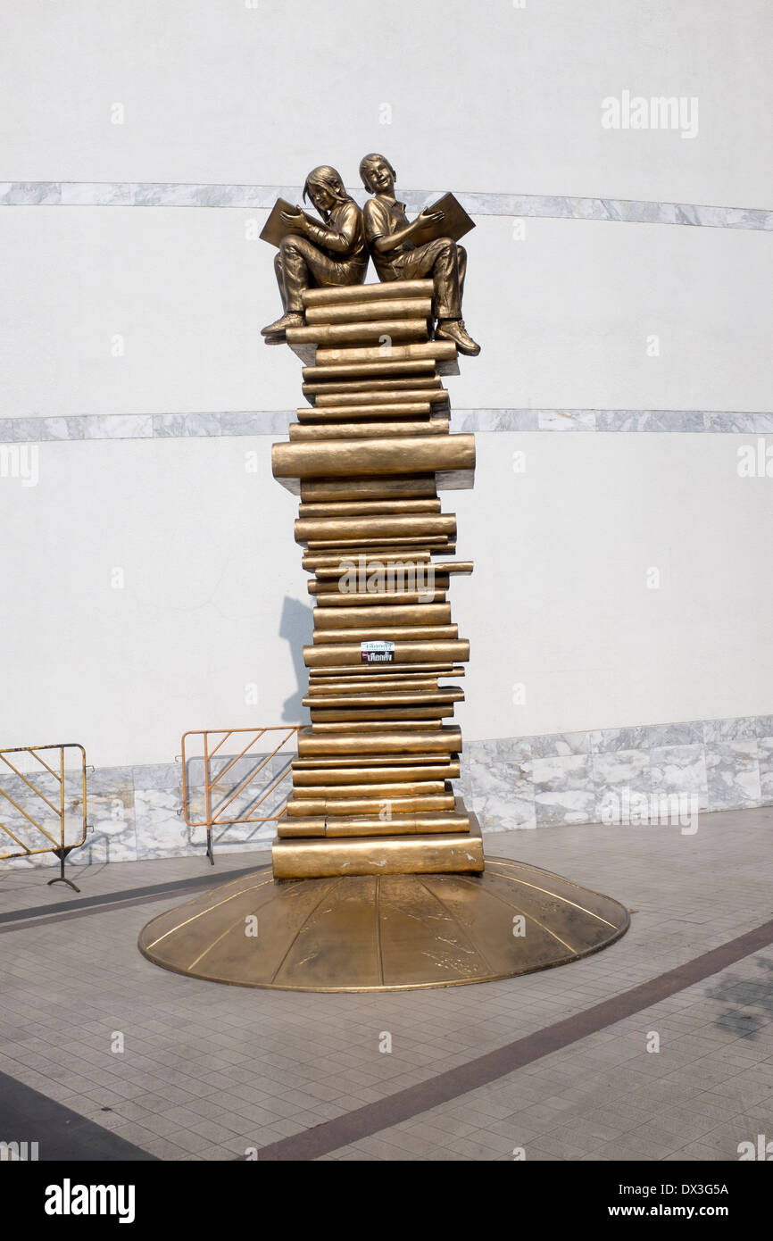 Modern art Sculpture of Boy and Girl reading on top of a stack of books outside the Bangkok Art and Culture Centre (BACC) Stock Photo