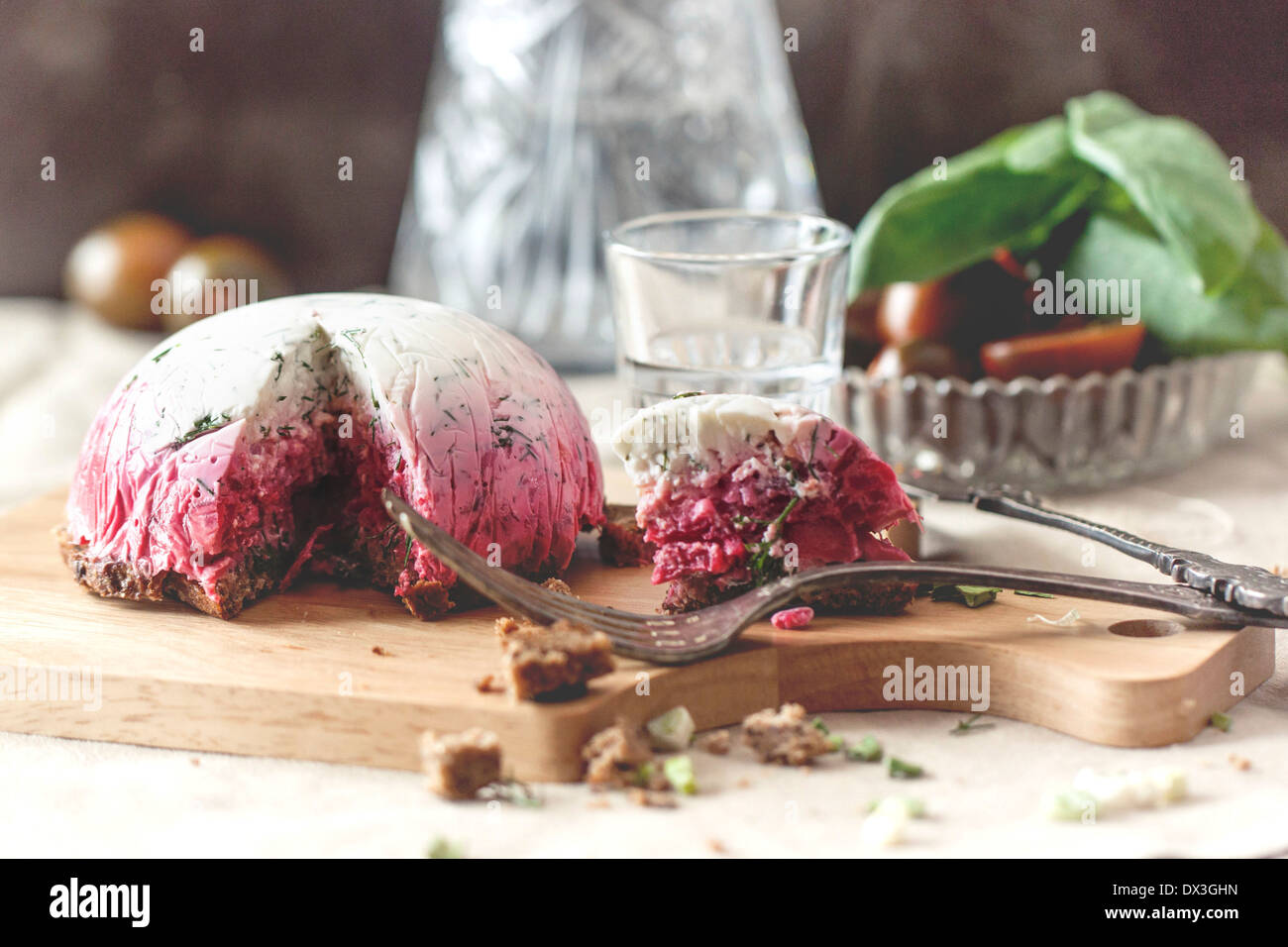 Delicious snack salad herring under a fur coat on wooden board with fork and russian vodka Stock Photo