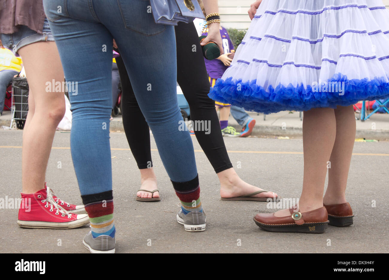 Expressive legs of four teenage girls standing in the street. Stock Photo