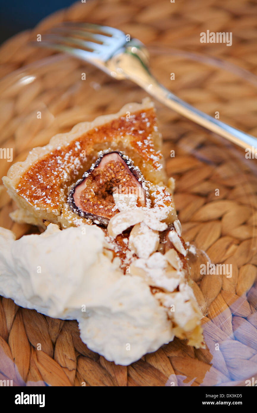 Slice of fruit tart pie with whipped cream on clear plate with fork, close up, high angle view Stock Photo