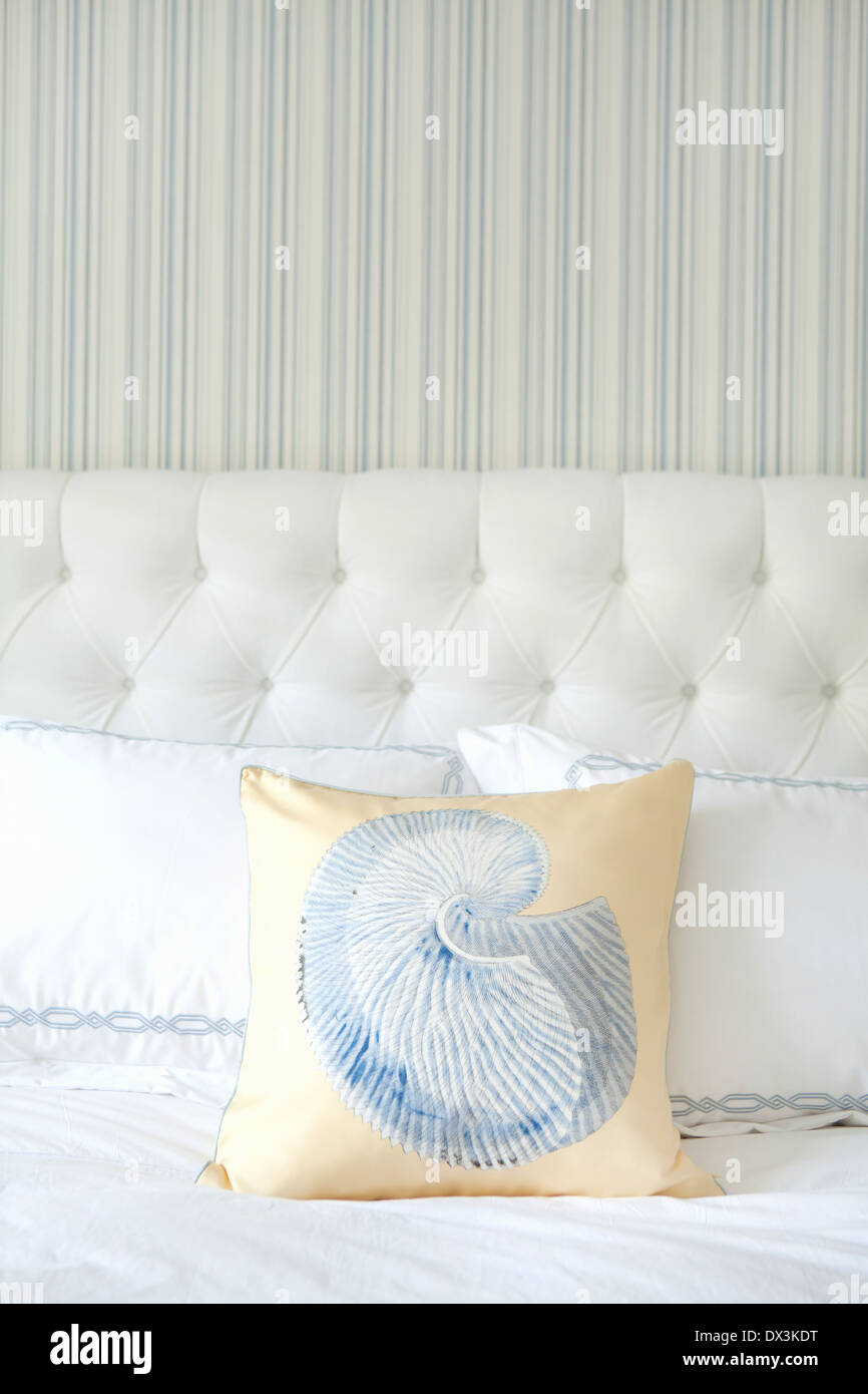 Seashell pillow and bed in blue and white bedroom Stock Photo