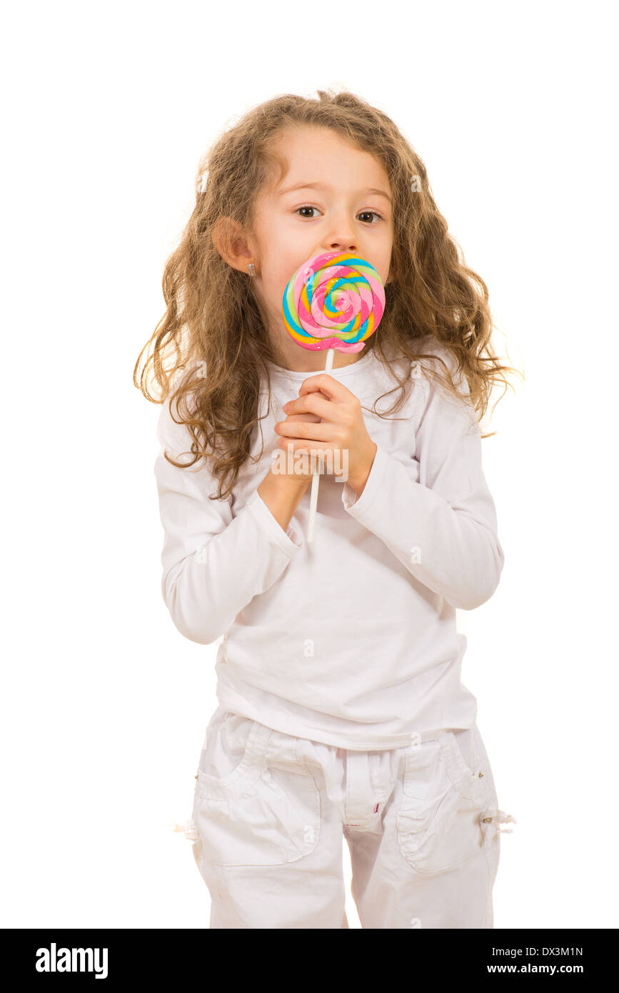Girl licking a tasty lollipop isolated on white background Stock Photo