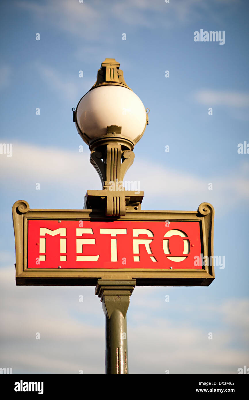 Metro subway street lamp sign against sunny blue sky with clouds, Paris, France, low angle view Stock Photo