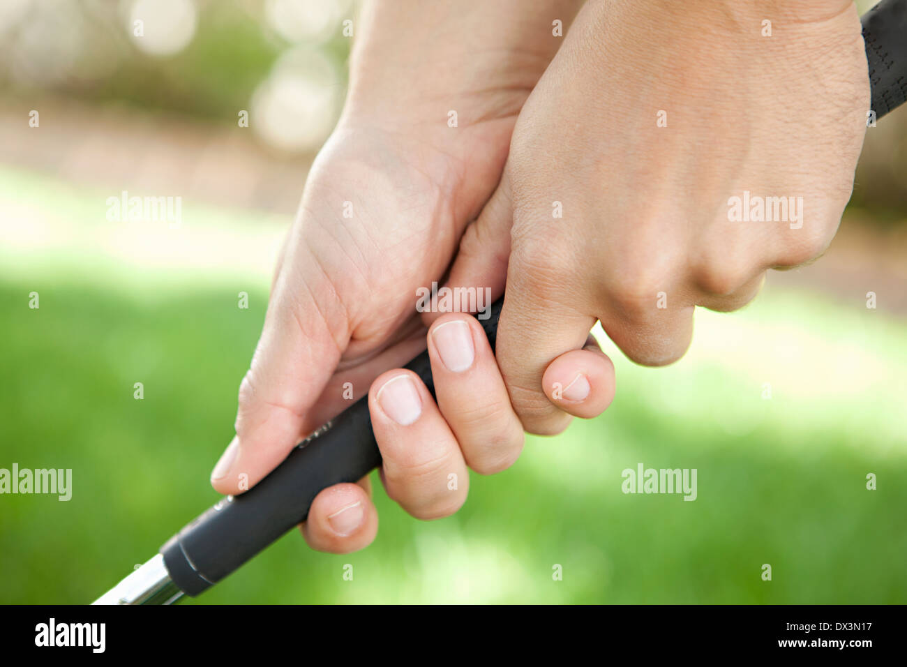 Man's hands holding golf club, close up Stock Photo