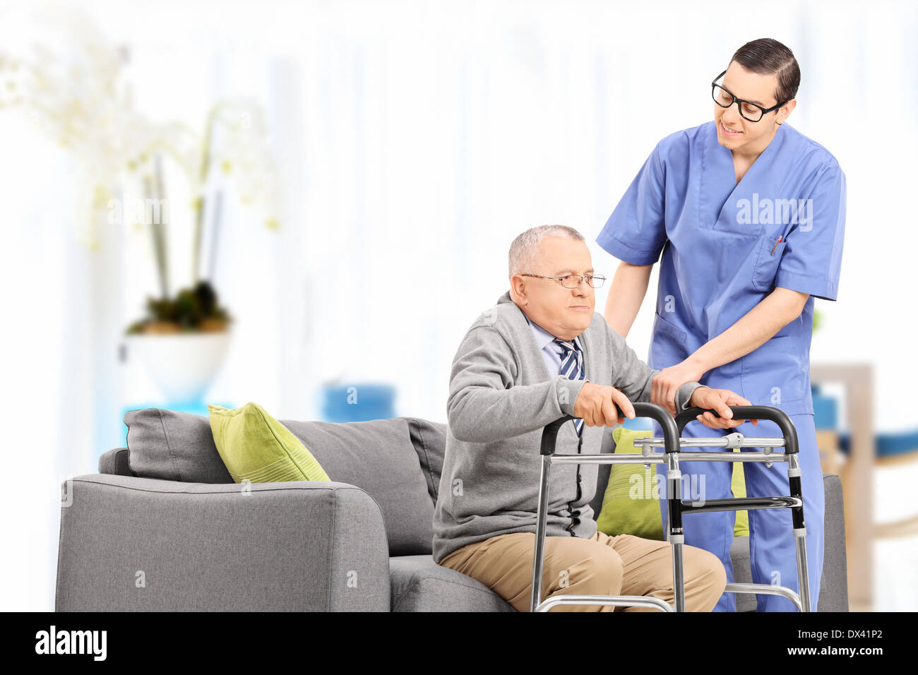 Male nurse helping an elderly gentleman to stand up in a nursing home Stock Photo