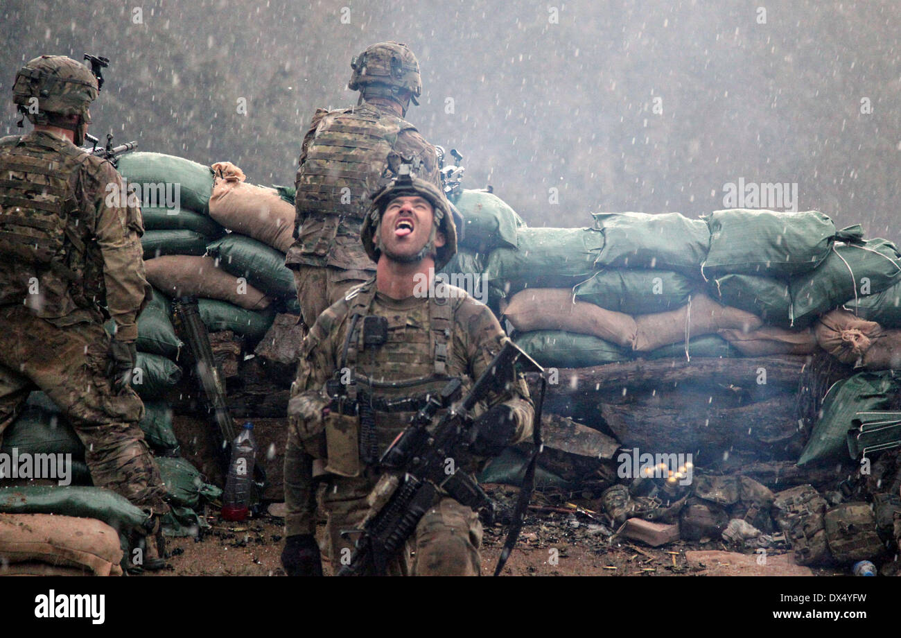 A US Army soldiers with the 101st Airborne Division relieved after a firefight with the Taliban opens his mouth towards the sky to taste the snow as it falls March 29, 2011 in the valley of Barawala Kalet, Kunar province Afghanistan. Stock Photo