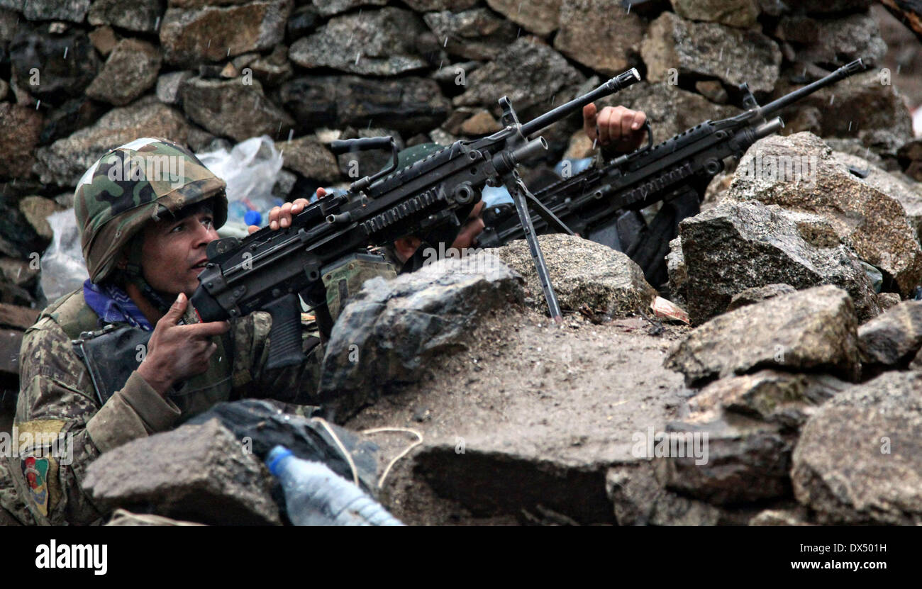 Afghan National Army soldiers uses a M-249 machine gun to return fire during a firefight with the Taliban March 29, 2011 in the valley of Barawala Kalet, Kunar province Afghanistan. Stock Photo