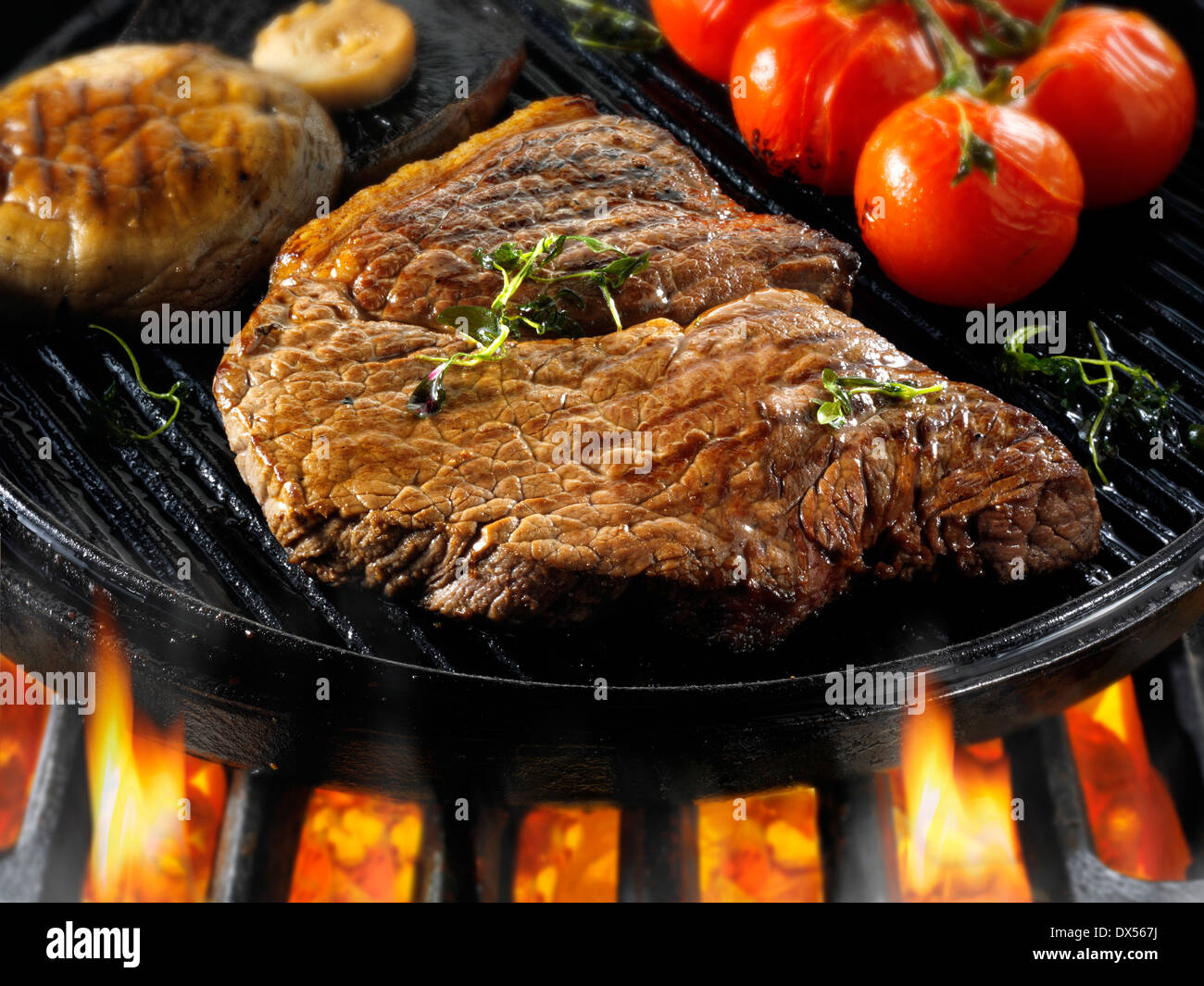 Beef rump steaks & tomatoes being pan fried on a bbq. Meat food photos
