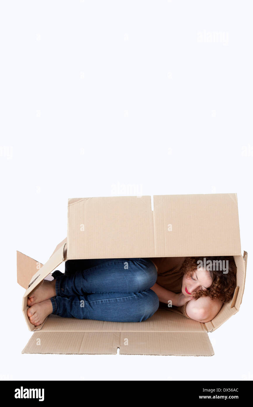 Young woman sleeping in a removal box Stock Photo