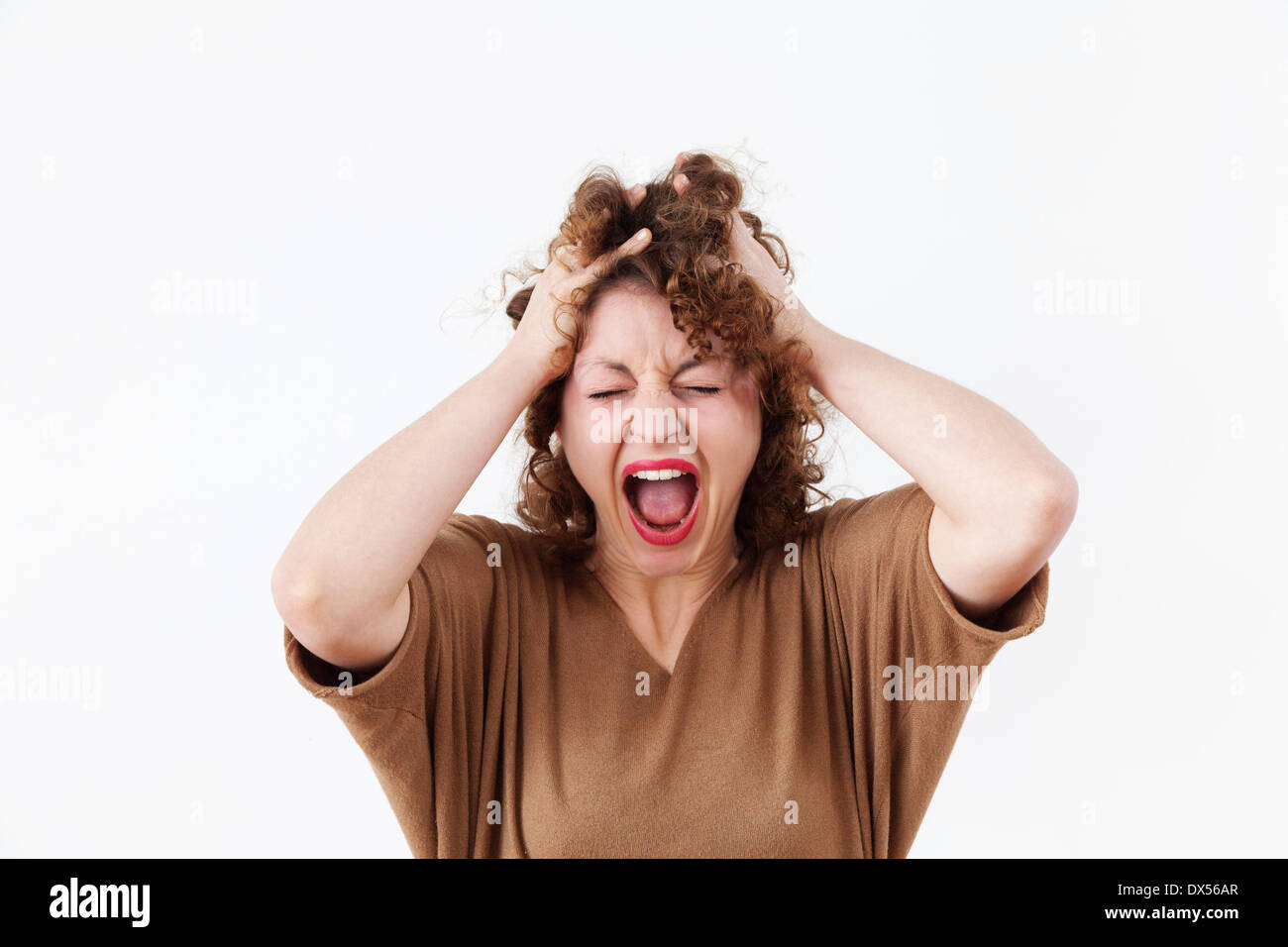 Screaming young woman tearing at her hair Stock Photo