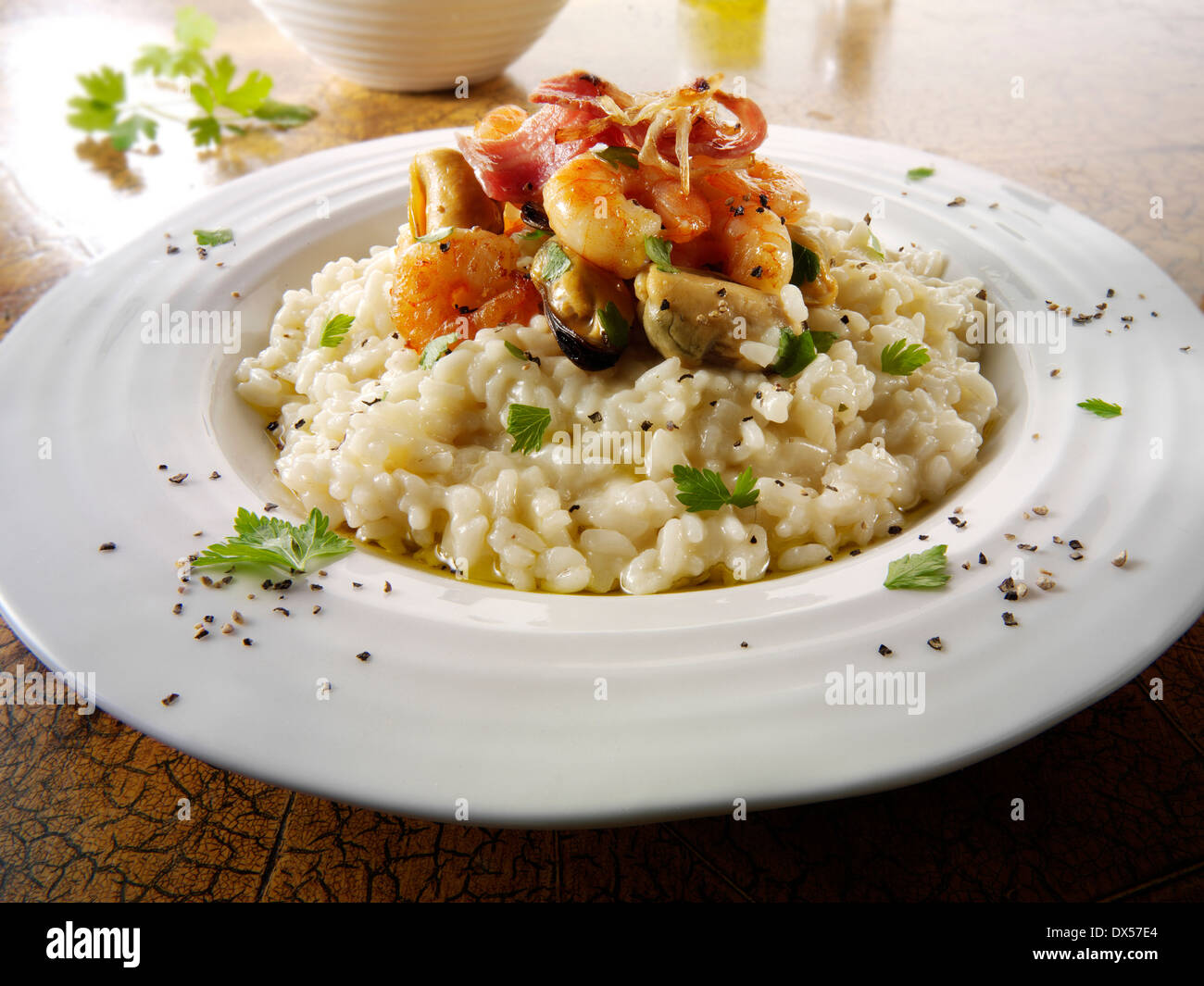 Fresh cooked prawns and mussels risotto, served plated on a table setting. Serving suggestion Stock Photo