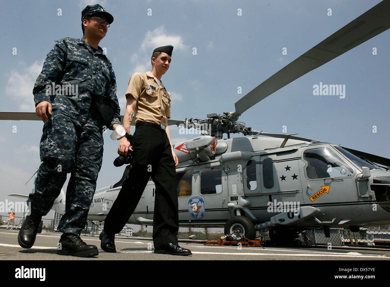 Manila, Philippines. 18th Mar, 2014. Soldiers from the U.S. Navy walk in front of an SH-60 helicopter on board of the USS Blue Ridge (LCC-19), the command flagship of United States Seventh Fleet in Manila, the Philippines, March 18, 2014. USS Blue Ridge arrived Tuesday at South Harbor in Manila for a goodwill visit, which will last until March 22. Credit:  Rouelle Umali/Xinhua/Alamy Live News Stock Photo