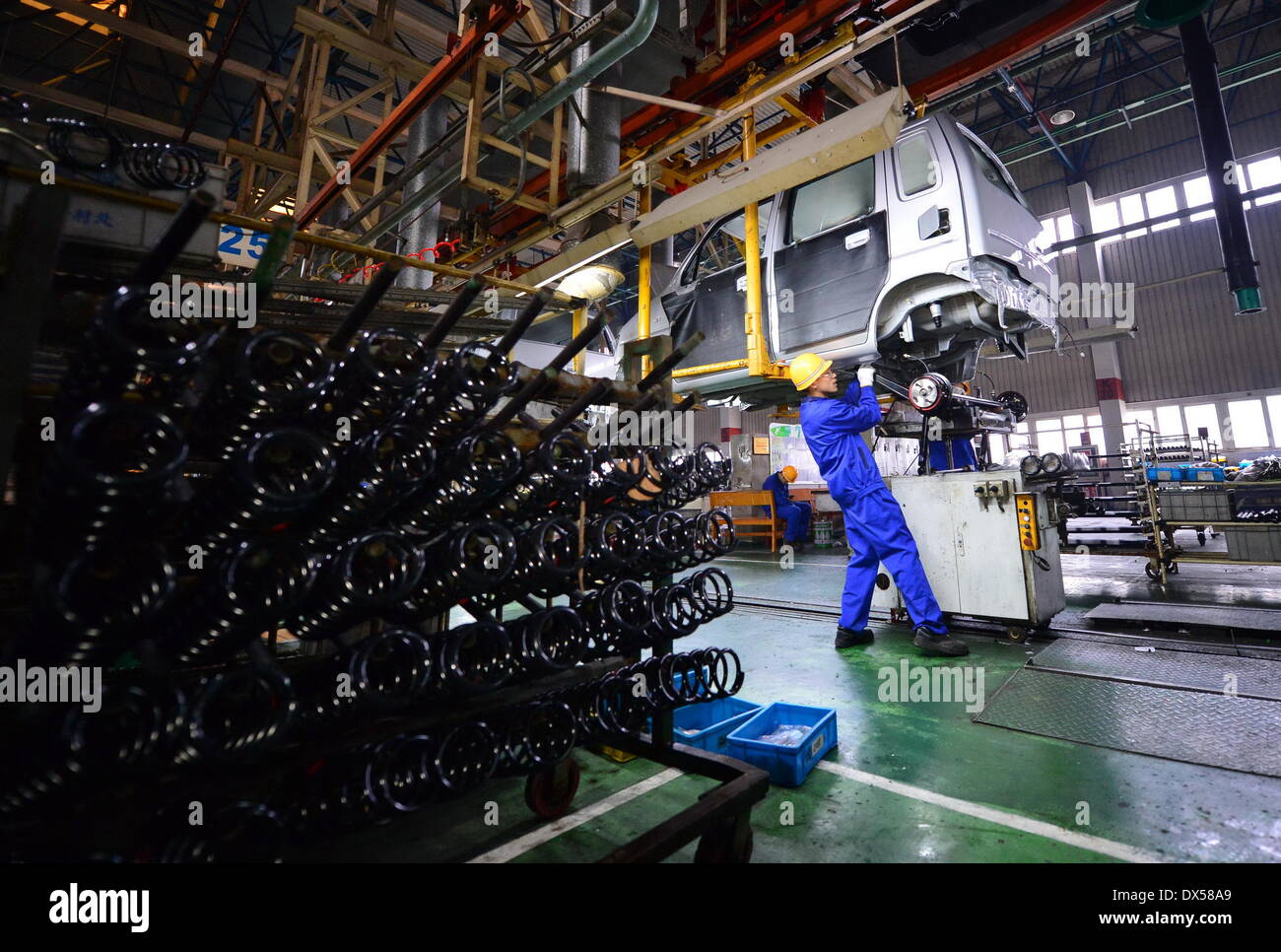 Nanchang, China. 18 March 2014. A worker works on an assembly line in Changhe Automobile Co. in east China's Jiangxi Province, March 12, 2014. In 2013, Beijing Automotive Group (BAIC), China's fifth-largest auto maker by sales, signed an agreement to pay about 80 million yuan (13 million U.S. dollars) for a 70-percent stake in Changhe Auto. The Jiangxi-based automaker expects to expand its yield capacity to 180,000 units in 2014, rising 60 percent year-on-year. © Xinhua/Alamy Live News Stock Photo