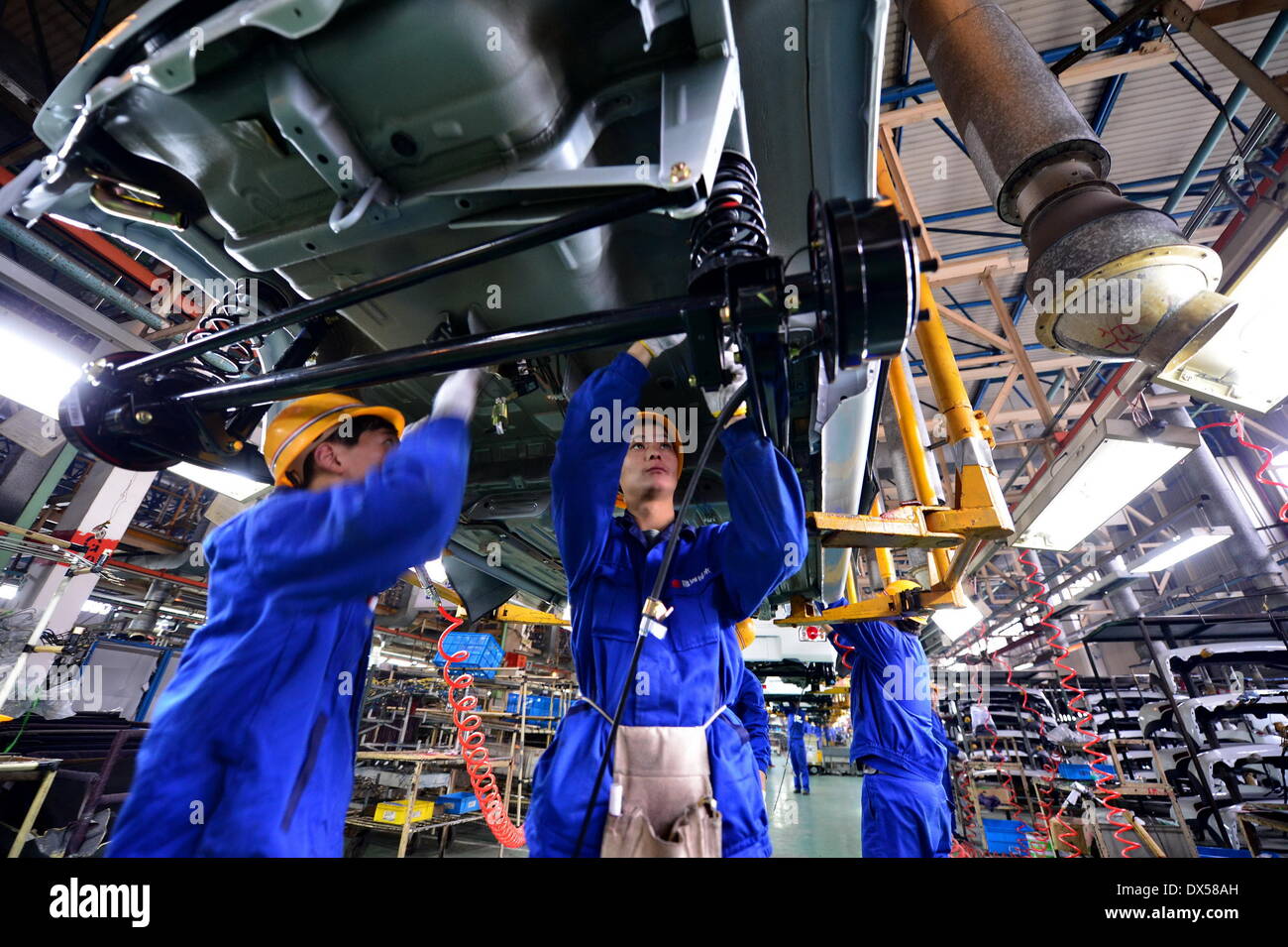 Nanchang, China. 18 March 2014. Workers work on an assembly line in Changhe Automobile Co. in east China's Jiangxi Province, March 12, 2014. In 2013, Beijing Automotive Group (BAIC), China's fifth-largest auto maker by sales, signed an agreement to pay about 80 million yuan (13 million U.S. dollars) for a 70-percent stake in Changhe Auto. The Jiangxi-based automaker expects to expand its yield capacity to 180,000 units in 2014, rising 60 percent year-on-year. © Xinhua/Alamy Live News Stock Photo