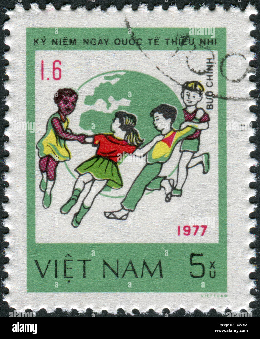 Postage stamp printed in Vietnam, dedicated to International Children's Day (1977), shows Children dance around Globe Stock Photo