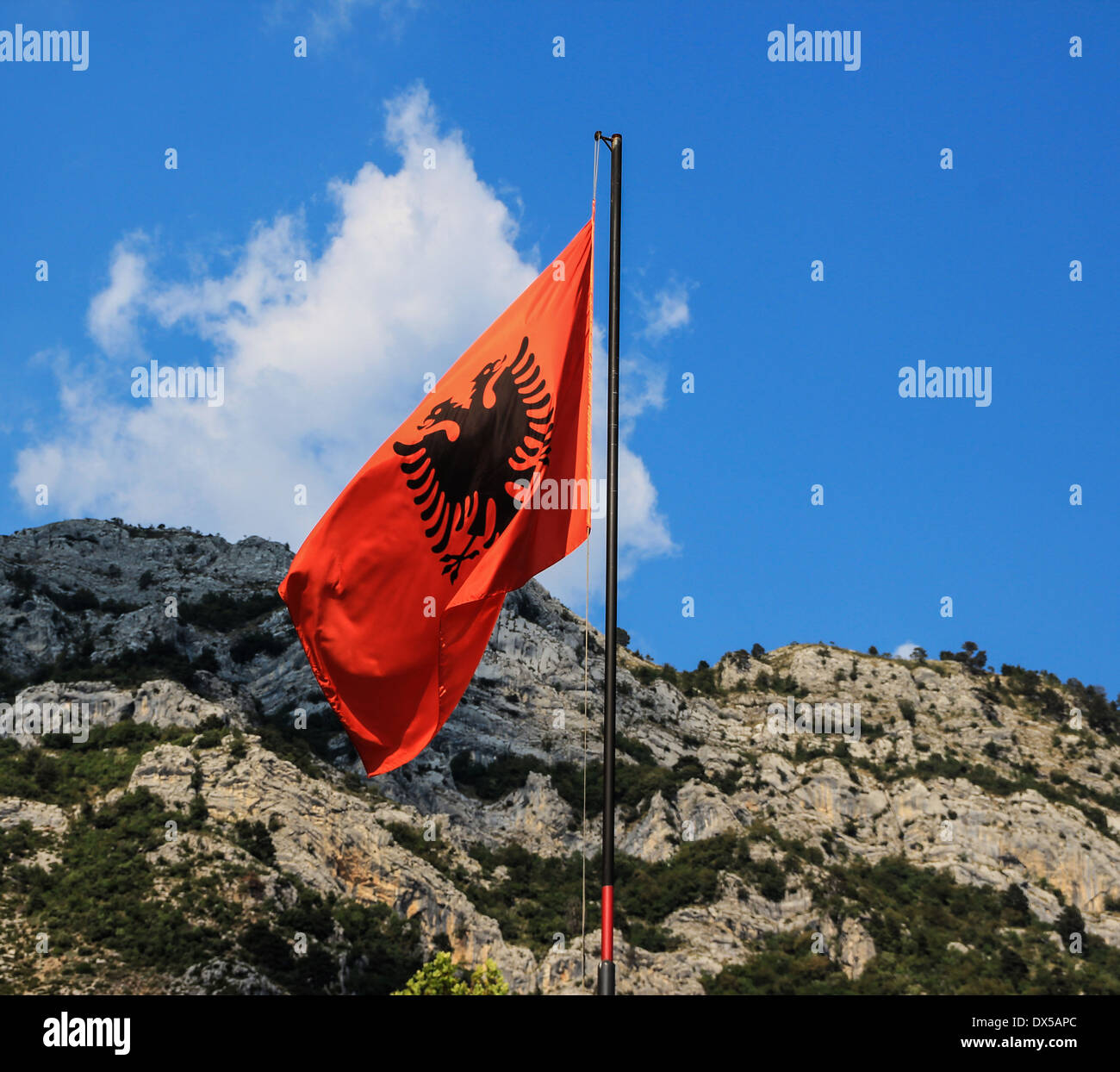 Albanian flag with black eagle on red background, with background the mountains around Kruja Castle, the Castle of national hero Skanderbeg Stock Photo