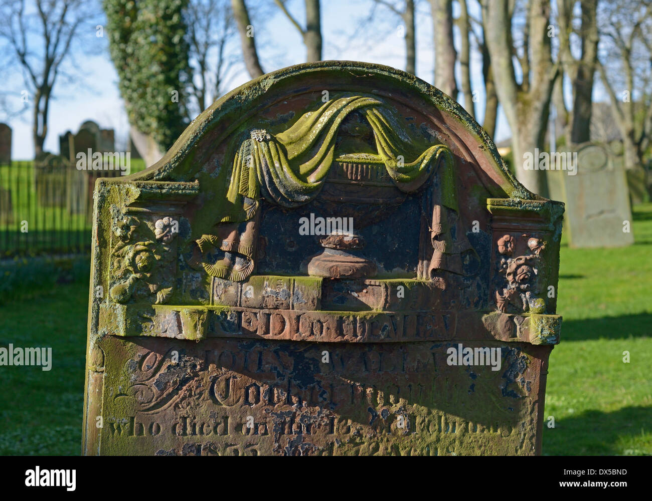 19th.Century gravestone with draped urn and books design. All Saints Church, Kirkgate, Cockermouth, Cumbria, England, U.K. Stock Photo