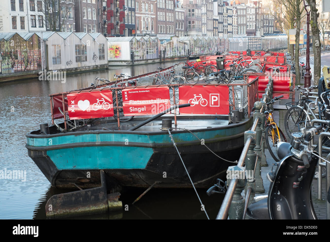 cycle park on a canal barge adjacent to flea market amsterdam netherlands Stock Photo