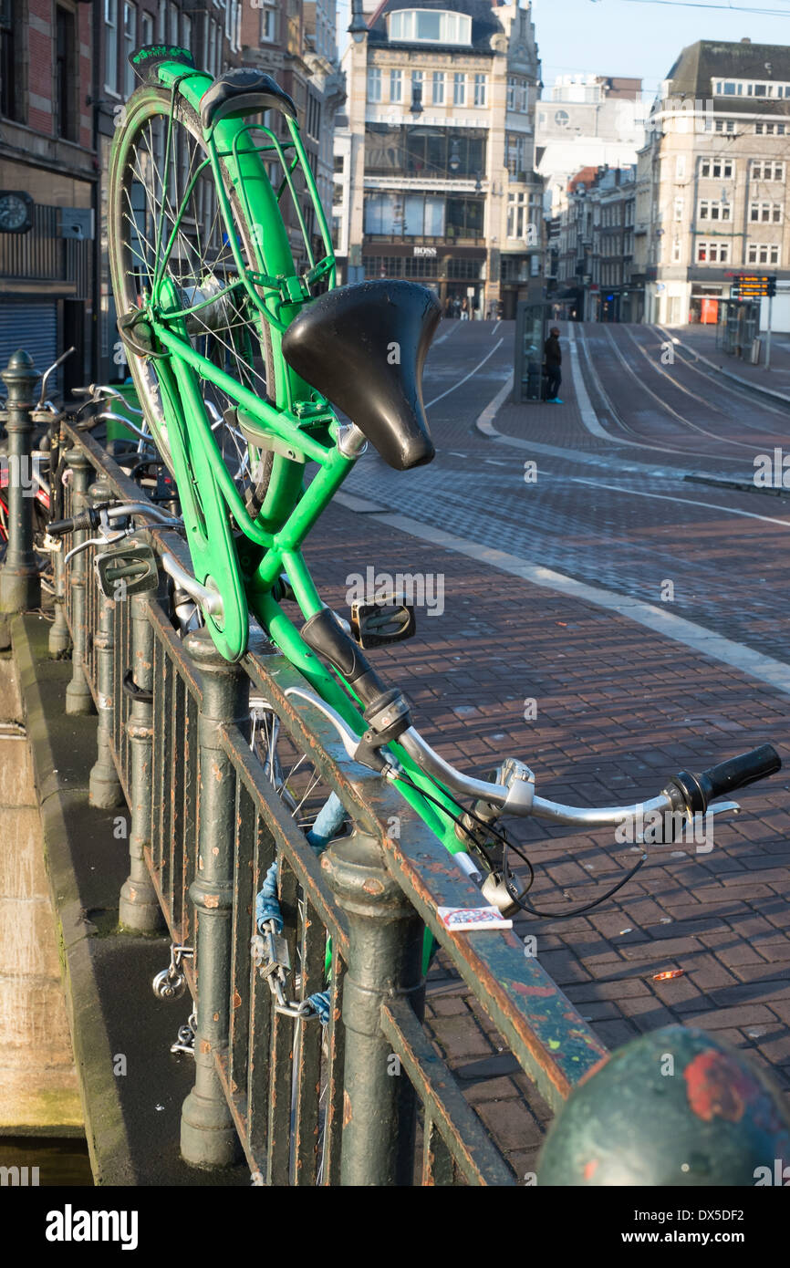 green bicycle parked on canal bridge amsterdam netherlands Stock Photo