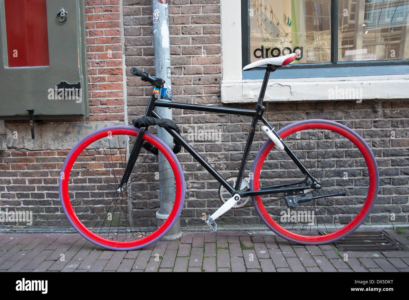 bicycle with black frame red wheels and purple tyres amsterdam netherlands Stock Photo