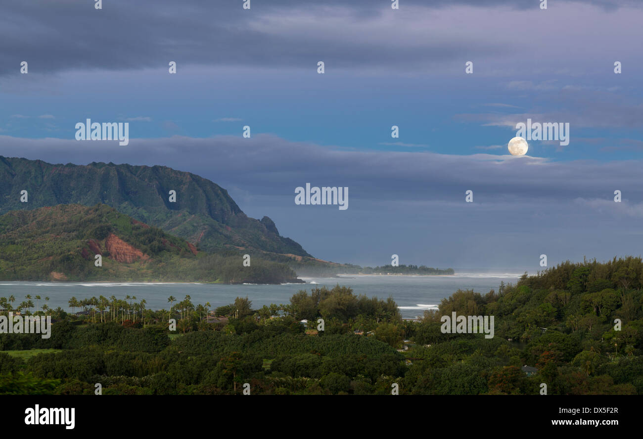 Bay at Hanalei in Kauai, Hawaii with the Na Pali mountain range in the background at dawn with moon setting Stock Photo