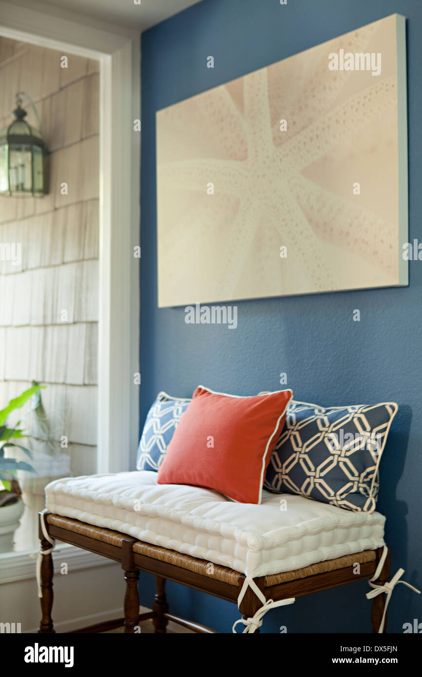 Starfish painting above red, white and blue bench pillows in foyer Stock Photo