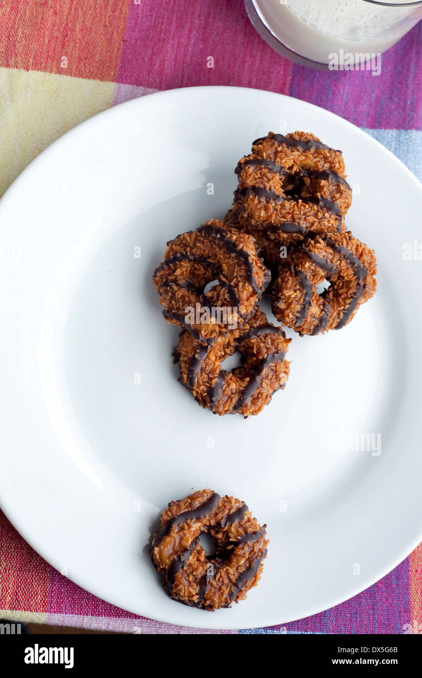 A plate of Girl Scout Cookies. Samoas/ Caramel deLites with a glass of